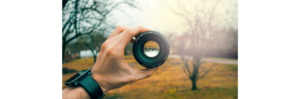 a hand holding a camera lens