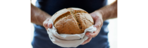 a person holding a loaf of bread