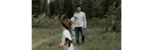 a man and a girl running in a field